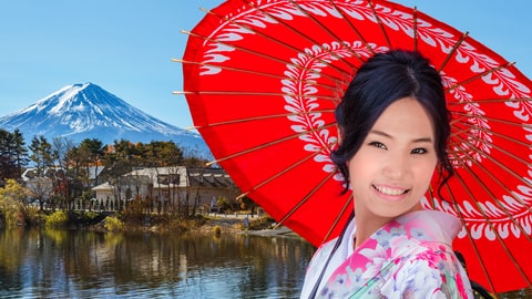 A Japanese woman in a colorful kimono poses with Mt. Fuji in the background, a perfect memory from Japan Youth Travel.