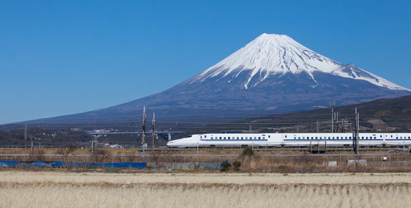 Shinkansen bullet train passing Mount Fuji Japan