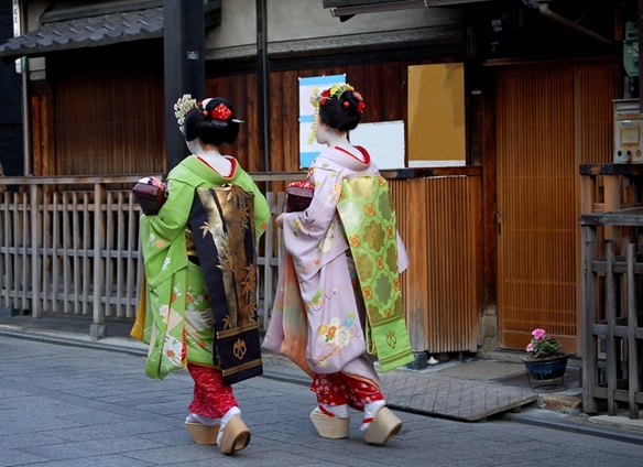 Maiko apprentice geisha in traditional kimono walking in Kyoto, Japan